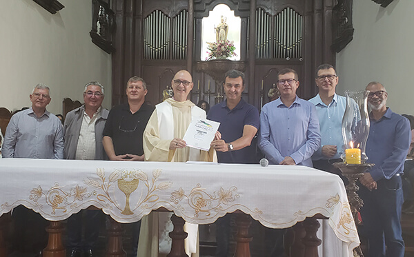 Padre Paulo recebe do prefeito Nilson Gaspar a escritura da Igreja Nossa Senhora da Candelária (Foto: Patrícia Lisboa/Dropes)
