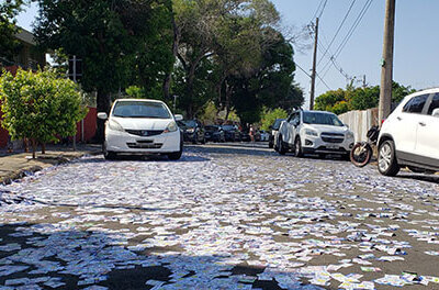 Santinhos espalhados na Rua Tapuia, em frente a escola Aurora, na Vila Maria Helena, em Indaiatuba (Foto: Patrícia Lisboa/Dropes)