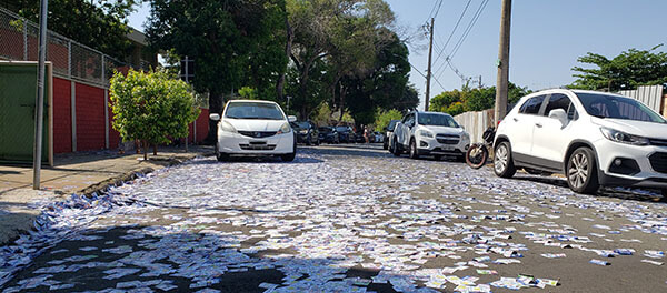 Santinhos espalhados na Rua Tapuia, em frente a escola Aurora, na Vila Maria Helena, em Indaiatuba (Foto: Patrícia Lisboa/Dropes)