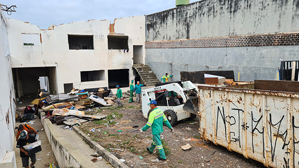 Equipe de limpeza retira sujeira de prédio abandonado, que foi interditado pela Prefeitura (Foto: Eduardo Turati/PMI)