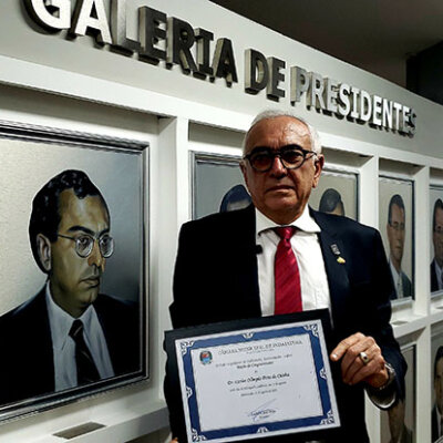 Advogado Carlos Olímpio ao lado do retrato dele na Galeria de Presidentes da Câmara de Indaiatuba (Foto: Patrícia Lisboa/Dropes)