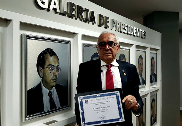 Advogado Carlos Olímpio ao lado do retrato dele na Galeria de Presidentes da Câmara de Indaiatuba (Foto: Patrícia Lisboa/Dropes)